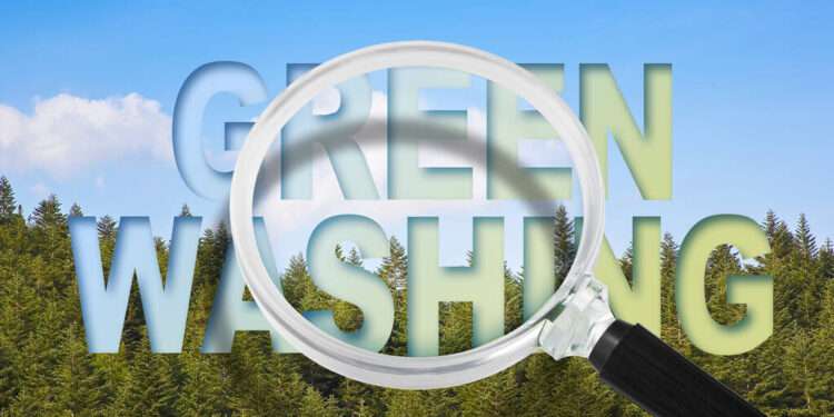 Alert to Greenwashing - concept with text against a woodland and magnifying glass